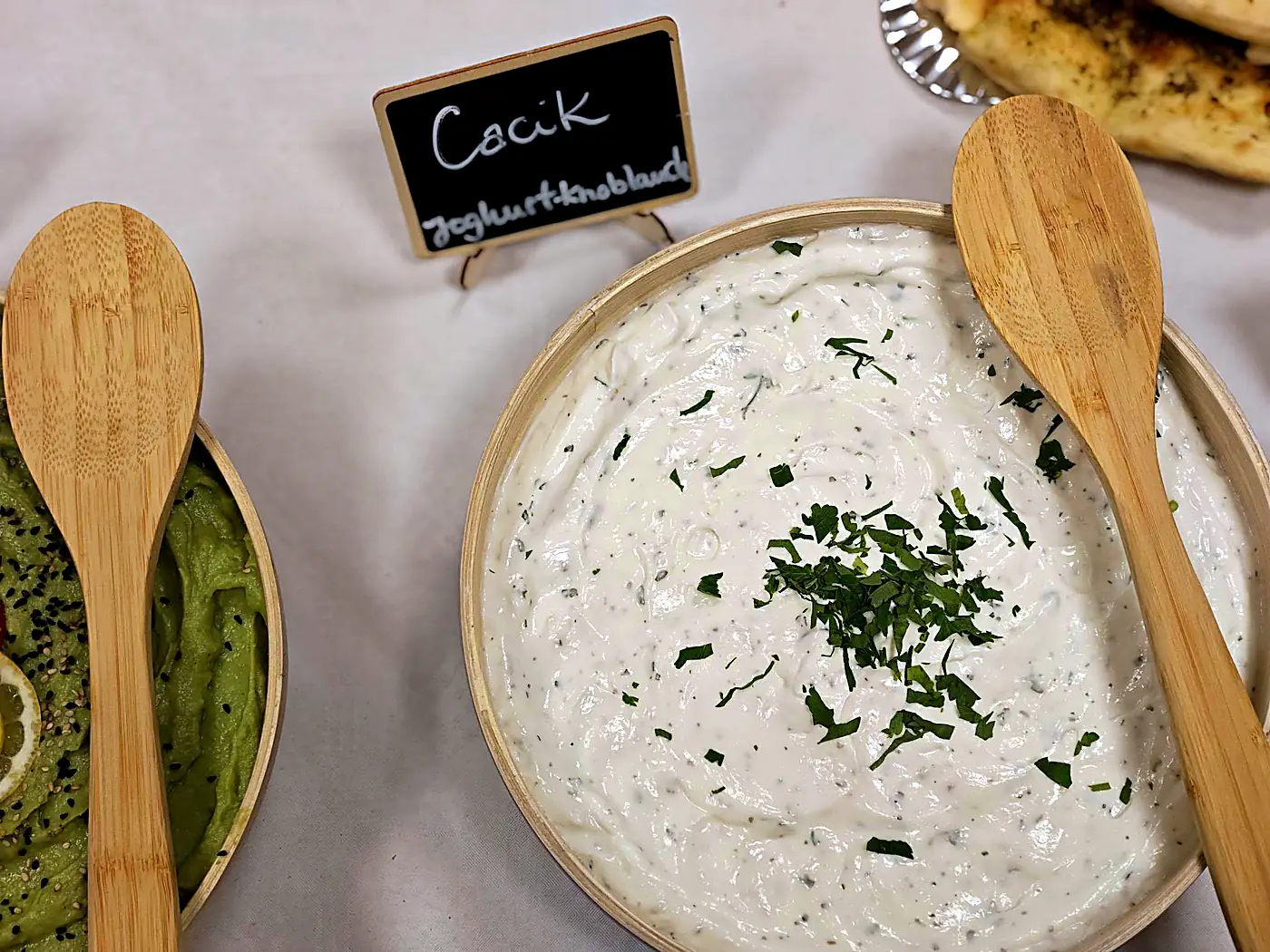 Cacik, Joghurt-Dip mit Knoblauch und Kräutern, mit Holzlöffeln auf dem Buffet