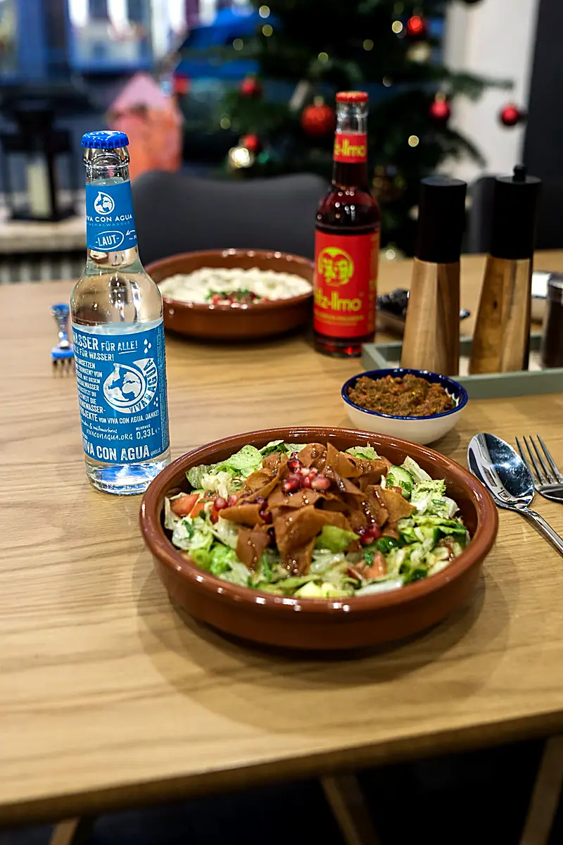 Fattoush-Salat in Tonschale, serviert am Tisch