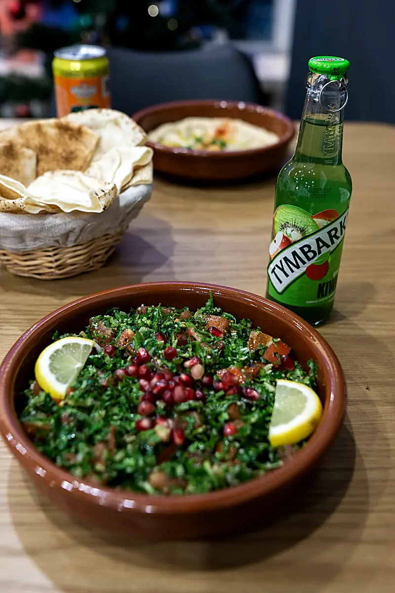 Tabbouleh in Tonschale mit Zitrone und Granatapfelkernen