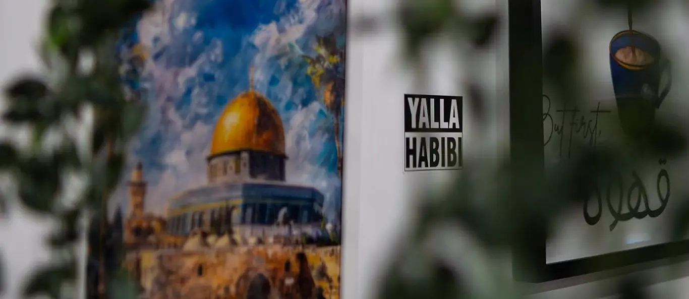 Gemälde des Felsendoms und Yalla-Habibi-Schild an der Wand des Gastraums
